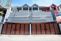 10 Bedroom House for Sale in Bang Lamung grey multi-storey exterior facade with white balustrade balconies and wooden security gate
