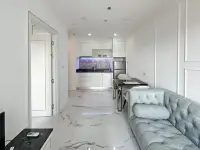 1 Bedroom Condo for Sale at The Empire Tower Pattaya open-plan living area with dining table and teal sofa