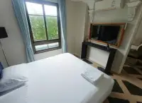 1 Bedroom Condo for Sale at Espana Condo Resort bed with wall-mounted TV and window view of pool area