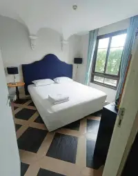 1 Bedroom Condo for Sale at Espana Condo Resort bedroom with navy blue upholstered headboard and patterned floor