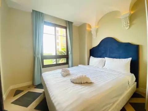 2 Bedroom Condo for Rent at Espana Condo Resort bedroom with blue upholstered headboard and window view