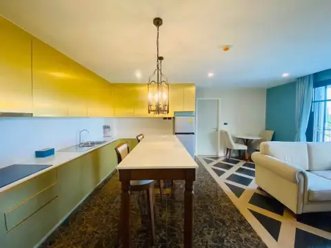 2 Bedroom Condo for Rent at Espana Condo Resort kitchen with yellow cabinetry and dining island