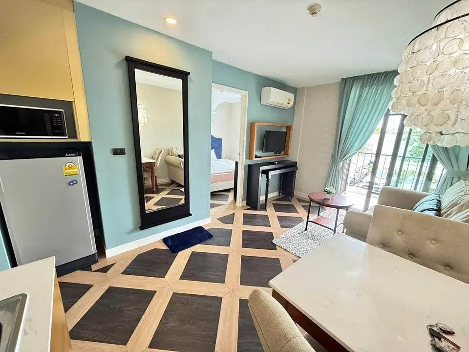 1 Bedroom Condo for Sale at Espana Condo Resort open living area with geometric tile floor, mirror, and balcony access
