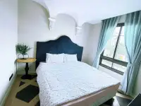 1 Bedroom Condo for Sale at Espana Condo Resort bedroom with blue upholstered headboard and curtained window