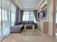 1 Bedroom Condo for Sale at Estanan Condo open living area with sectional sofa, glass coffee table, and sheer curtains