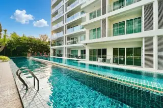 Sunset Boulevard Residence 2 aerial view of condo buildings, lush green courtyard, and blue swimming pool.