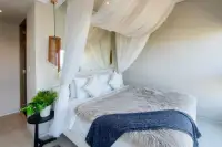 2 Bedroom Condo for Sale at Veranda Residence Pattaya bedroom with white canopy bed and decorative plant.