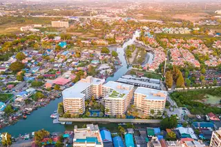 Whale Marina aerial view of buildings, river, green spaces, and surrounding residential area.