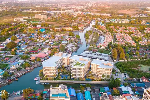 Whale Marina aerial view of buildings, river, green spaces, and surrounding residential area.
