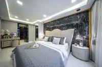2 Bedroom Condo for Sale at Grand Solaire Noble luxury master bedroom with black marble feature wall and gold pendant lights