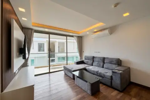 2 Bedroom Condo for Sale at The Peak Towers spacious living room with sectional sofa and glass balcony door