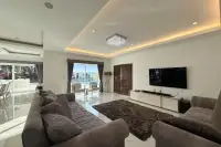 8 Bedroom House for Sale in Pong spacious living room with crystal chandelier, large TV, grey sofas and pool view
