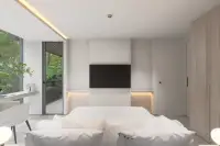 1 Bedroom Condo for Sale at Celine Wongamat modern bedroom with wall-mounted TV, ambient LED lighting, and garden balcony access