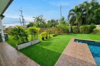 3 Bedroom House for Rent at Garden Ville 1 lush garden with potted tropical plants, green lawn, and poolside patio