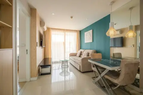 1 Bedroom Condo for Sale at Grande Caribbean living room with teal accent wall and dining area
