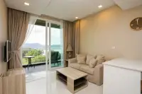 1 Bedroom Condo for Sale at Del Mare cozy living room with neutral sofa, wooden coffee table, and glass doors opening to sea-view balcony