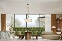 4 Bedroom House for Sale at Solava Pattaya open-plan living and dining area with marble island, brass chandelier and garden views