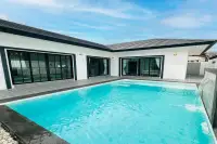 3 Bedroom House for Sale in Nong Prue large private swimming pool with waterfall feature and black-framed glass facade