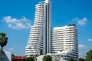 Jomtien Beach Paradise: Aerial view of the condo complex with two swimming pools and lush green landscaping.