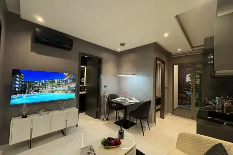 1 Bedroom Condo for Sale at Zenith Pattaya living area with wall-mounted TV, dining table, and mirrored accents