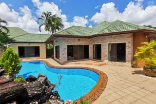 SP Village 3 private freeform pool with rock feature, stone-clad bungalow exterior and tropical garden