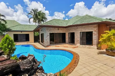 SP Village 3 private freeform pool with rock feature, stone-clad bungalow exterior and tropical garden