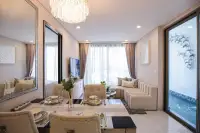 1 Bedroom Condo for Sale at Copacabana Coral Reef spacious living and dining area with large wall mirror, cream sofa, TV and private pool access