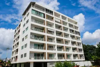 Jomtien Hill Resort Condominium outdoor swimming pool with blue water, lounge chairs, and palm trees.
