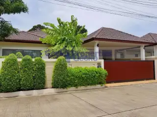 Garden Ville 1 modern house exterior with white wall, dark brown gate, and covered parking area.