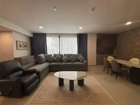 2 Bedroom Condo for Rent at Gardenia Pattaya open living and dining area with stone accent wall
