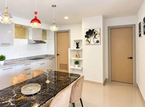 2 Bedroom Condo for Rent at Gardenia Pattaya kitchen view with dining table, decor shelf and bedroom doors