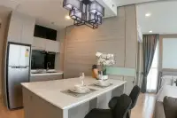 1 Bedroom Condo for Sale at Cetus Beachfront modern kitchen with white island countertop, stainless steel fridge, and pendant light