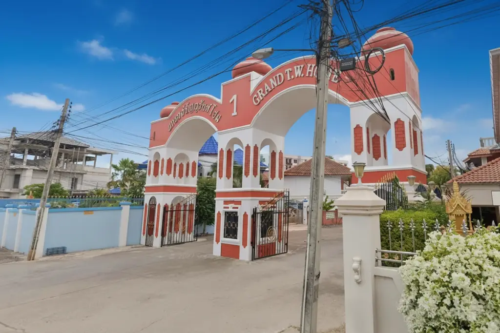 Grand Tanyawan Home impressive red and white arched entrance gate with community name.