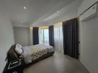 3 Bedroom Condo for Sale at Grand View Condo master bedroom with sea-view balcony and curtains