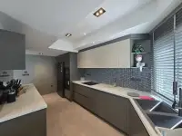 2 Bedroom Condo for Sale at Grand View Condo galley kitchen with dark cabinetry, double sink and window blinds