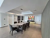 2 Bedroom Condo for Sale at Grand View Condo dining area with marble table, dark upholstered chairs and wall art