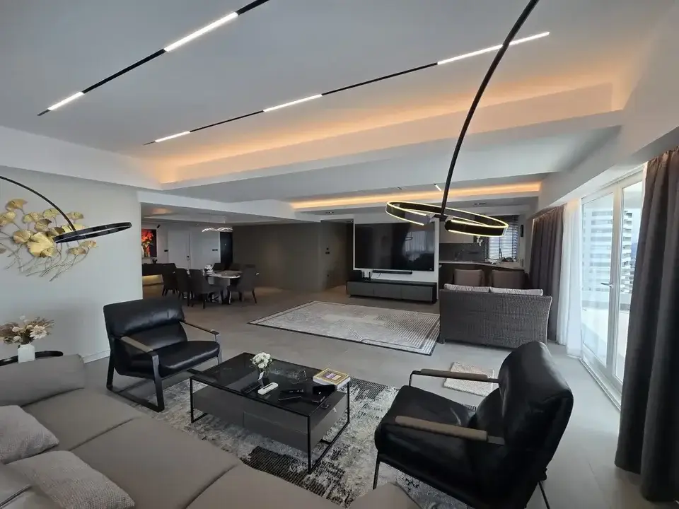 2 Bedroom Condo for Sale at Grand View Condo open-plan living room with black leather armchairs and LED ceiling lights
