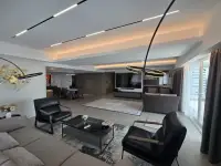 2 Bedroom Condo for Sale at Grand View Condo open-plan living room with black leather armchairs and LED ceiling lights