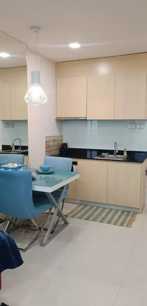 1 Bedroom Condo for Rent at Grande Caribbean kitchen with wood cabinets, black countertop, and dining table