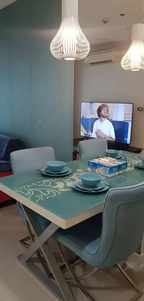 1 Bedroom Condo for Rent at Grande Caribbean dining area with teal chairs and TV view from table