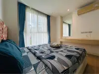 2 Bedroom Condo for Sale at Grande Caribbean bedroom with blue curtains and patterned bedspread by window