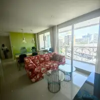 2 Bedroom Condo for Sale at Grande Caribbean living room with floral sofa, glass tables and balcony view