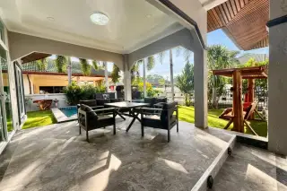SP Village 3 covered outdoor patio with black dining set, lush lawn, private pool and children's play area