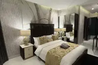 Studio Condo for Sale at Grand Solaire Noble elegantly furnished bedroom with gold table lamp, marble feature wall, and mirrored wardrobe