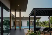 3 Bedroom House for Sale at Baan Pattaya 7 (Ascent) pool area with sun loungers under a pergola and modern architectural elements.