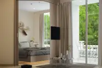 1 Bedroom Condo for Sale at Harmonia City Garden hallway view into bedroom with wall art, TV and balcony seating area