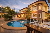5 Bedroom House for Sale in Nong Prue, exterior at dusk with pool, string lights, and outdoor dining table.