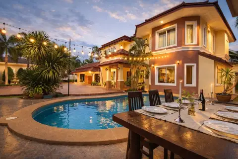 5 Bedroom House for Sale in Nong Prue, exterior at dusk with pool, string lights, and outdoor dining table.