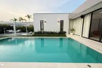 3 Bedroom House for Sale & Rent at The Prospect: Swimming pool with turquoise water, surrounded by modern white walls and lush greenery.