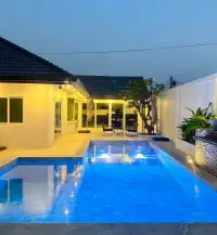 3 Bedroom House for Sale at Hillside Village Pattaya private swimming pool and patio illuminated at dusk